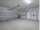 Garage with ample storage cabinets and a side-mounted garage door opener at 701 Cottage Park Ln, Leesburg, FL 34748
