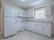 A well-lit kitchen with white cabinets, modern appliances and a view from the window at 701 Cottage Park Ln, Leesburg, FL 34748