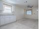 Open-concept kitchen/living space featuring white cabinets and tile flooring at 701 Cottage Park Ln, Leesburg, FL 34748