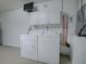 Laundry area with white washer and dryer, cabinets, and wall mounted tv at 701 Cottage Park Ln, Leesburg, FL 34748