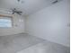 Neutral living room featuring soft tile, a ceiling fan, and a window with blinds for privacy and natural light at 701 Cottage Park Ln, Leesburg, FL 34748