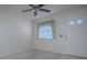 Bright, carpeted living room featuring a ceiling fan, window, and entry door at 701 Cottage Park Ln, Leesburg, FL 34748