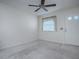 Neutral living room featuring a ceiling fan and a window with blinds for privacy and natural light at 701 Cottage Park Ln, Leesburg, FL 34748