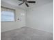 Neutral living room featuring soft carpet, a ceiling fan, and a window with blinds for privacy and natural light at 701 Cottage Park Ln, Leesburg, FL 34748
