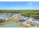 A birds-eye view of a lovely residential neighborhood next to a peaceful pond and a lush green forest at 7250 Trundle Ter, The Villages, FL 34762
