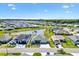 Aerial view showcases a planned community with serene lake, manicured lawns, and modern homes at 7250 Trundle Ter, The Villages, FL 34762