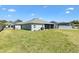 Lush backyard showing a well-kept lawn and the home's neutral-toned exterior at 7250 Trundle Ter, The Villages, FL 34762