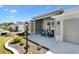 Covered front porch with decor and furniture create a welcoming entrance to this single Gathering home at 7250 Trundle Ter, The Villages, FL 34762