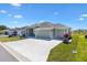 Spacious three car garage on this neutral colored single Gathering home with nicely landscaped front yard at 7250 Trundle Ter, The Villages, FL 34762