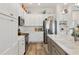 Modern kitchen featuring white cabinets, stainless steel appliances, and quartz countertops, creating a bright and functional space at 7250 Trundle Ter, The Villages, FL 34762