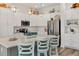 Spacious kitchen features island with bar seating, white cabinetry and stainless steel appliances at 7250 Trundle Ter, The Villages, FL 34762