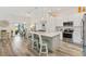 Open-concept kitchen with modern appliances, stylish island with seating and views to dining area at 7250 Trundle Ter, The Villages, FL 34762
