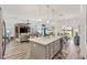Large kitchen island with sink, bar seating, with open view to living room and dining area at 7250 Trundle Ter, The Villages, FL 34762