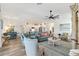 Open-concept living room flowing into kitchen and dining area, with stylish furnishings and plenty of natural light at 7250 Trundle Ter, The Villages, FL 34762