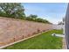 Well-manicured backyard featuring lush green grass, tasteful landscaping, and privacy wall at 7539 Hagemeyer Pl, The Villages, FL 34762