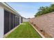 Well-manicured backyard featuring lush green grass, tasteful landscaping, and privacy wall at 7539 Hagemeyer Pl, The Villages, FL 34762