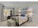 Bright bedroom features a black metal bed frame, plush carpet and neutral wall color at 7539 Hagemeyer Pl, The Villages, FL 34762