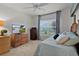Bedroom features a wooden dresser and a view of the property on the television at 7539 Hagemeyer Pl, The Villages, FL 34762