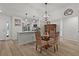 Open-concept dining area features chandelier lighting, and flows into an updated kitchen space at 7539 Hagemeyer Pl, The Villages, FL 34762