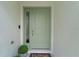 Front door featuring a stylish paint color, glass accents, modern hardware and a welcoming entrance mat at 7539 Hagemeyer Pl, The Villages, FL 34762