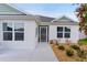 Front exterior featuring a stylish screen door, manicured landscaping and windows that add natural light to the interior at 7539 Hagemeyer Pl, The Villages, FL 34762