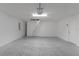Spacious, clean garage featuring bright overhead lighting and access ladder to attic or storage space at 7539 Hagemeyer Pl, The Villages, FL 34762