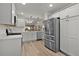 Modern kitchen featuring stainless steel appliances, white cabinetry, and luxury vinyl plank flooring at 7539 Hagemeyer Pl, The Villages, FL 34762