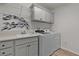 Bright laundry room with sink, white cabinets and a modern washer and dryer at 7539 Hagemeyer Pl, The Villages, FL 34762