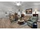 Bright living room featuring modern furniture, a ceiling fan, and a view to the dining area and front of the house at 7539 Hagemeyer Pl, The Villages, FL 34762