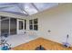 Covered patio with white table, access to screened-in porch, and rock garden at 7539 Hagemeyer Pl, The Villages, FL 34762