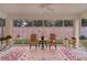 Bright sunroom with colorful rugs and seating overlooks a private fenced yard at 7539 Hagemeyer Pl, The Villages, FL 34762