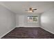 Bright living room with modern wood-look floors, a ceiling fan, and a large window offering natural light at 900 Maple Ave, Fruitland Park, FL 34731