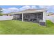 Well-maintained backyard with a screened patio, lush lawn, and privacy fence at 916 Carmillion Ct, Groveland, FL 34736