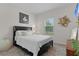 This bedroom features a bed with nightstand, window and vibrant area rug at 916 Carmillion Ct, Groveland, FL 34736