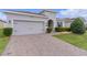 Charming home featuring a paver driveway, attached garage, and well-maintained landscaping at 916 Carmillion Ct, Groveland, FL 34736