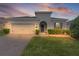 Charming home featuring a paver driveway, attached garage, and well-maintained landscaping at 916 Carmillion Ct, Groveland, FL 34736