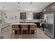 Kitchen with stainless appliances, dark wood cabinetry, and center island seating, perfect for casual dining and entertaining at 916 Carmillion Ct, Groveland, FL 34736