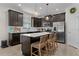 Spacious kitchen boasts dark cabinetry, stainless steel appliances, a center island with seating, and stylish pendant lighting at 916 Carmillion Ct, Groveland, FL 34736