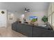 Open-concept living room features a large gray sectional sofa, wood flooring, and neutral tones for a cozy feel at 916 Carmillion Ct, Groveland, FL 34736