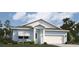 Charming one-story home featuring light blue siding, white trim, and a two-car garage for convenient parking at 987 Fiesta Key Cir, Lady Lake, FL 32159