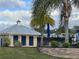 Community pool house with blue shutters surrounded by lush landscaping and trees at 987 Fiesta Key Cir, Lady Lake, FL 32159