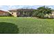 Expansive backyard view showcasing the screened-in patio and lush green lawn perfect for outdoor activities and enjoyment at 10199 Mainsail Dr, Oxford, FL 34484