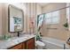 Full bathroom with decorative mirror, single sink vanity and shower/tub combo at 10199 Mainsail Dr, Oxford, FL 34484