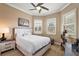 Comfortable bedroom with natural light, wood-look floors and neutral decor at 10199 Mainsail Dr, Oxford, FL 34484