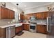 Charming kitchen with stainless steel appliances, wood cabinetry, and a farmhouse sink at 10199 Mainsail Dr, Oxford, FL 34484