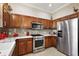 Stylish kitchen with stainless steel appliances, custom wood cabinets, and quartz countertops at 10199 Mainsail Dr, Oxford, FL 34484