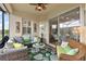 Inviting screened patio with stylish wicker furniture, green accents, and a ceiling fan for outdoor relaxation and comfort at 10199 Mainsail Dr, Oxford, FL 34484