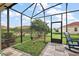 Screened patio with a secure pet area, rockin chair, and a view of the well-maintained backyard at 10199 Mainsail Dr, Oxford, FL 34484