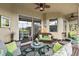Covered patio features ample seating, a stylish rug, and seamless indoor-outdoor living with sliding glass doors at 10199 Mainsail Dr, Oxford, FL 34484