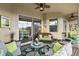 Covered patio features ample seating, a stylish rug, and seamless indoor-outdoor living with sliding glass doors at 10199 Mainsail Dr, Oxford, FL 34484